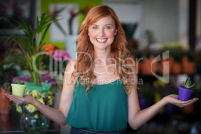 Female florist holding plant pot at flower shop