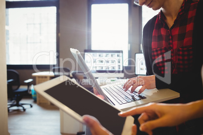 Two female graphic designer using digital tablet and laptop