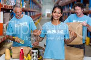 Happy volunteer showing her tee-shirt to the camera in front of