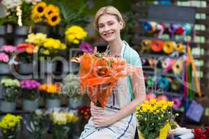 Happy female florist holding flower bouquet