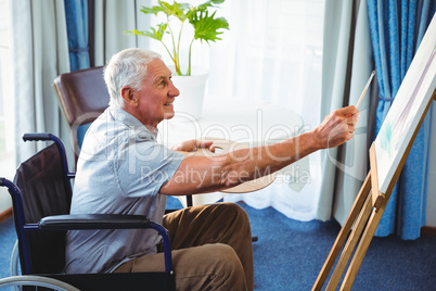 Senior man using brush and easel