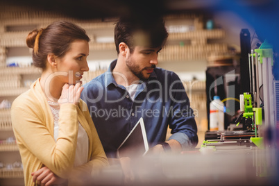 Graphic designers holding digital tablet looking at a model