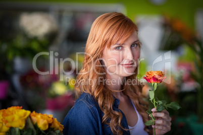 Female florist holding a rose flower