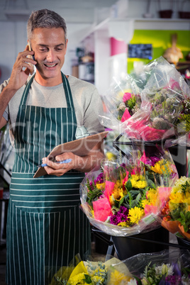 Male florist taking order on mobile phone