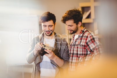 Graphic designer using camera with his coworker