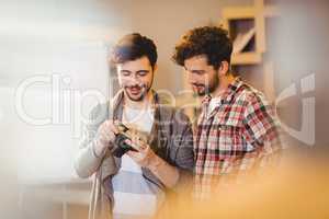 Graphic designer using camera with his coworker