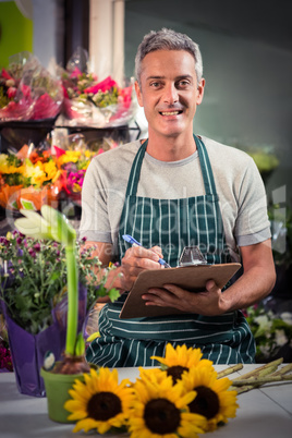 Male florist writing on clipboard