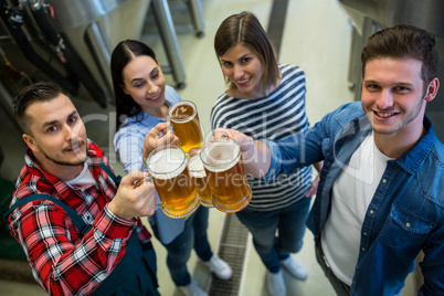 Brewers toasting beers at brewery