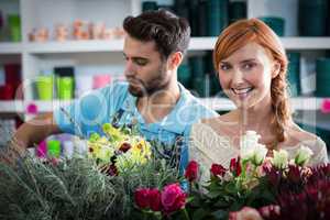 Happy couple arranging flowers