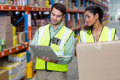 Workers are standing and looking a laptop