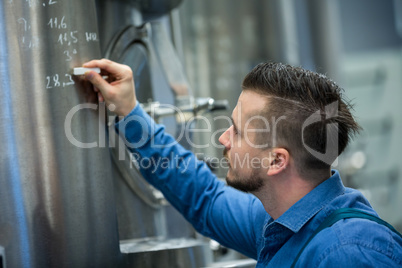 Maintained worker writing on tank