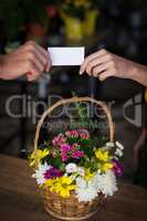 Hand of female florist giving visiting card to customer