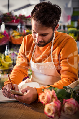 Male florist noting order in dairy