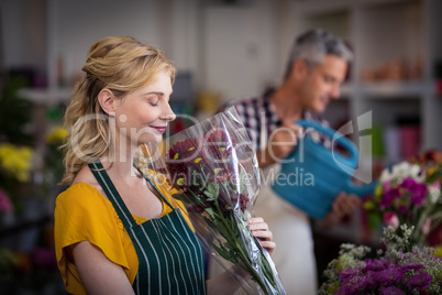 Happy female florist smelling a flower bouquet