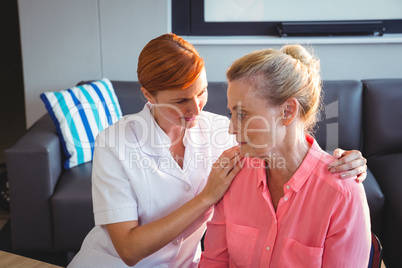 Nurse taking care of a sad senior woman