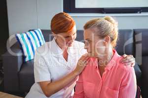 Nurse taking care of a sad senior woman