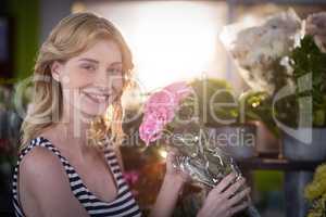 Female florist holding bunch of flower in flower shop