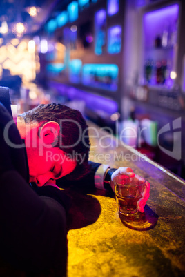 Drunken man sleeping on bar counter