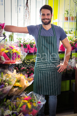 Male florist with hands on hip at his flower shop