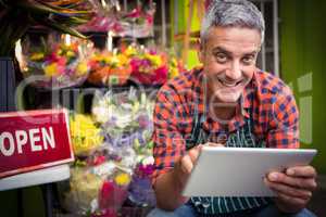 Male florist using digital tablet