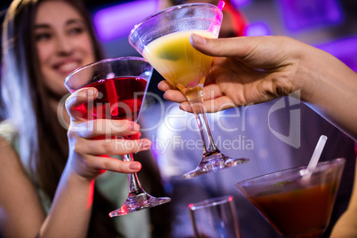 Friends toasting cocktail at bar counter