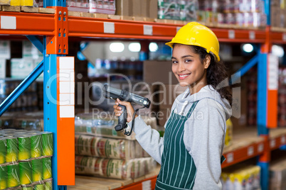 Female warehouse worker using digital equipment