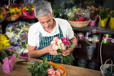 Male florist holding bunch of roses