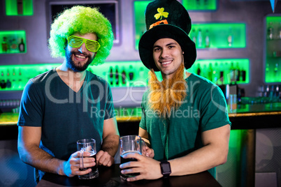 Male friends smiling and holding beer mugs