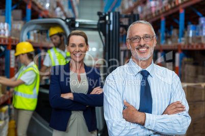 Focus of manages are smiling and posing with crossed arms