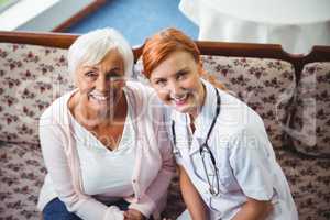 Senior woman and nurse smiling at camera