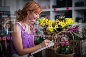 Female florist writing on the clipboard