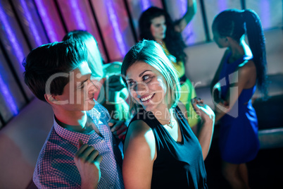 Smiling friends dancing on dance floor