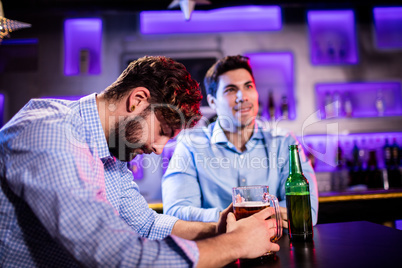 Depressed man having beer at bar counter