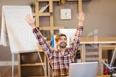 Excited graphic designer sitting with laptop