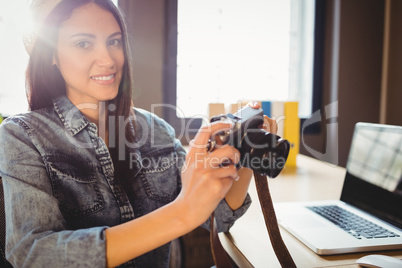 Graphic designer looking at pictures in digital camera