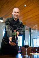 Waiter holding a bottle of red wine