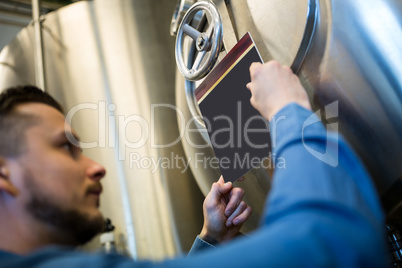 Maintained worker writing on tank