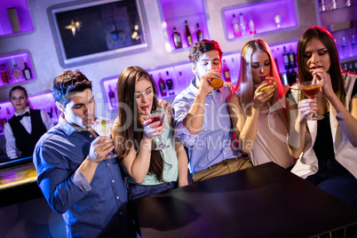 Group of friends having cocktail at bar counter