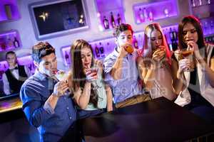 Group of friends having cocktail at bar counter