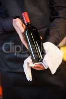 Waiter holding a bottle of red wine