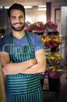 Male florist with arms crossed in flower shop