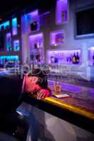 Depressed man having whisky at bar counter