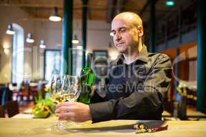 Waiter holding glasses and a bottle of white wine
