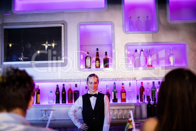 Barmaid standing with hand on hip on bar counter