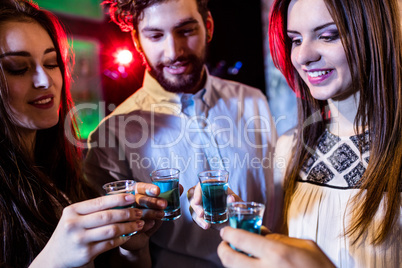 Group of friends toasting tequila shot glasses