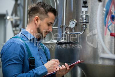 maintenance worker writing on clipboard