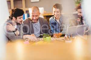 Graphic designer using digital tablet with his coworker