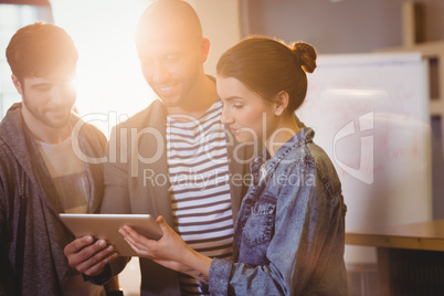 Graphic designer using digital tablet with his coworker