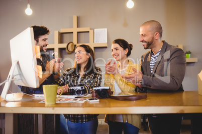 Team of graphic designers applauding a colleague