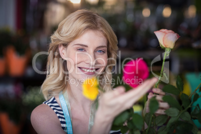 Smiling female florist arranging flower bouquet in vase at flowe